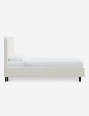 Side view of Clementine cream sherpa platform bed with undulating lined headboard