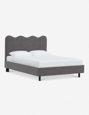Angled view of Clementine steel velvet platform bed with undulating lined headboard