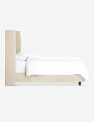 Side view of the Adara natural linen upholstered bed.