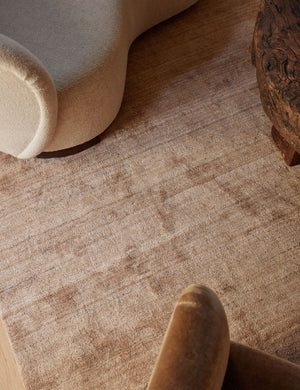 Close up of the Chiltern mauve rug under a linen sofa, brown accent chair, and wooden coffee table
