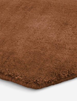 Close up of the corner of the Damara solid viscose rug in rose.