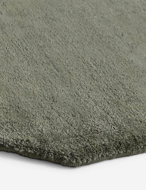 Close up of the corner of the Damara solid viscose rug in sage.