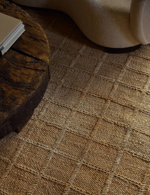 Close up of the Harper rug laying under a round coffee table and a swivel chair