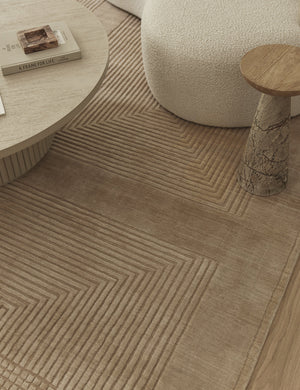 Halden handwoven carved design rug styled with a marble side table, boucle accent chair and round coffee table.