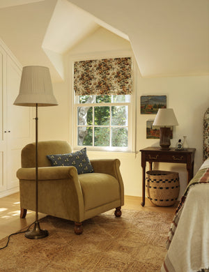 Lily slim metal stem adjustable height floor lamp by Heidi Caillier styled next to an accent chair