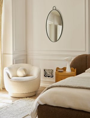  Fern scalloped back boucle upholstered swivel chair styled in a corner of a bedroom