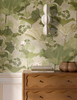 Lotus lush botanical wallpaper by Aimee Song on a wall behind a dresser