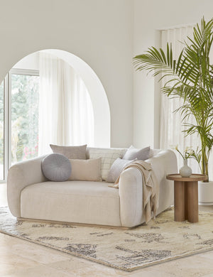 Charlotte ice blue square velvet pillow sits on a linen lounger with other blue and neutral toned throw pillows