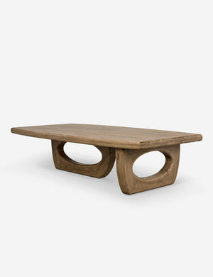 Angled view of the Doris walnut coffee table with cutout oval legs
