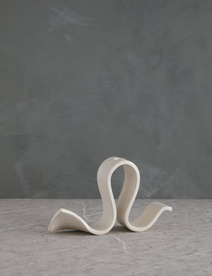 Whit white Candelabra by SIN with an undulating silhouette and space for one taper candle
