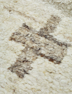 A close-up of the pattern on the Acoma cream and tan plus-sign patterned Moroccan area rug with diamond border.