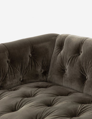 Close-up of the corner of the Afia tufted gray-brown velvet sofa with nailhead trim and light wood base