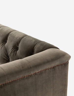 Close-up of the corner of the Afia tufted gray-brown velvet sofa with nailhead trim and light wood base