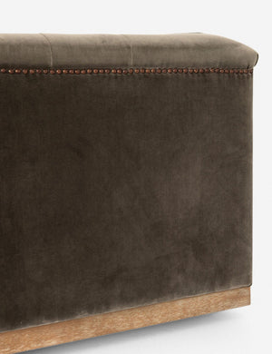 Close-up of the corner of the Afia tufted gray-brown velvet sofa with nailhead trim and light wood base