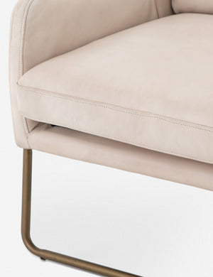 Close-up of the metal legs and the cushioning on the Dove ivory leather accent chair