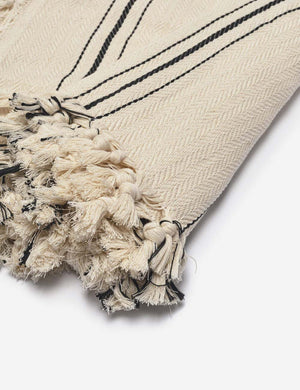 Close-up of the fringed ends on the Monte viso natural and black striped bed cover by House No. 23