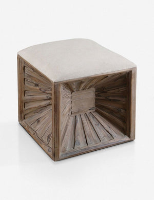 Angled view of the Hannah wooden ottoman with accented base and ivory cushioning