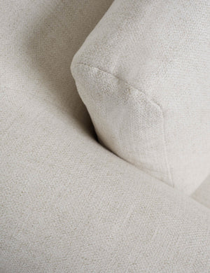 Close-up of the corner of the Harlowe ivory oversized media lounger chair with acacia wood base
