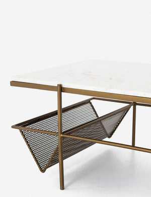 Close-up of the left side of the Thina rectangular marble coffee table with gold hardware and magazine shelf