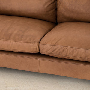 Close-up of the stitch work and cushioning on the center of the Jocelyn brown leather sofa