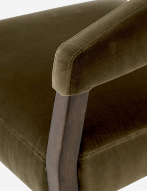 Close-up of the deep-oak frame and arm of the Lyssa olive velvet accent chair