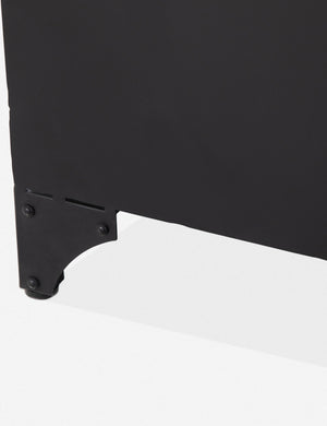 A foot on the Marjorie black iron sideboard with glass paneled doors