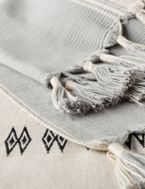 Close-up of the tasseled edges on the Halia gray and white geometric throw blanket
