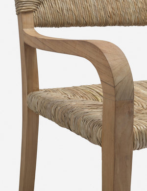 Angled close-up of the arm and seat on the Nolani woven rattan arm chair