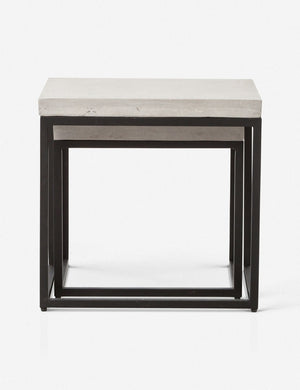 The Kallia indoor and outdoor nesting side tables with iron bases and concrete tops with the smaller table fully nested into the bigger table